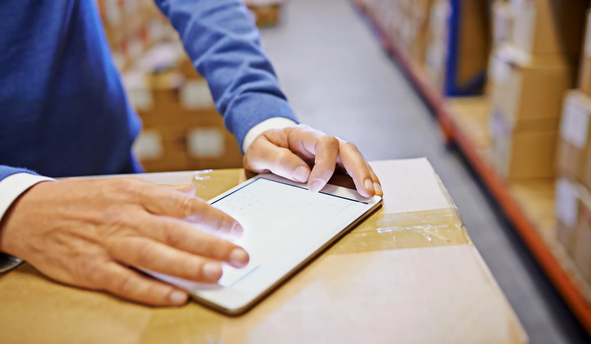 A person who is on his phone in a warehouse full of carboard