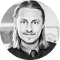 Black and white photo of a smiling man with long hair and a goatee.