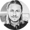 Black and white photo of a smiling man with long hair and a goatee.