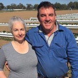 Growers Michael and Kylie Cashen from Bidgee Strawberries and Cream standing in their paddock with hydroponic rows behind.