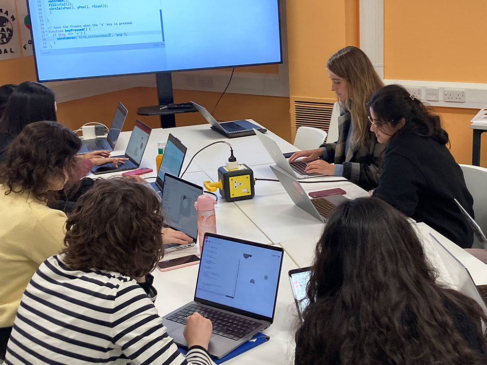 Participants in a workshop writing code on their laptops.