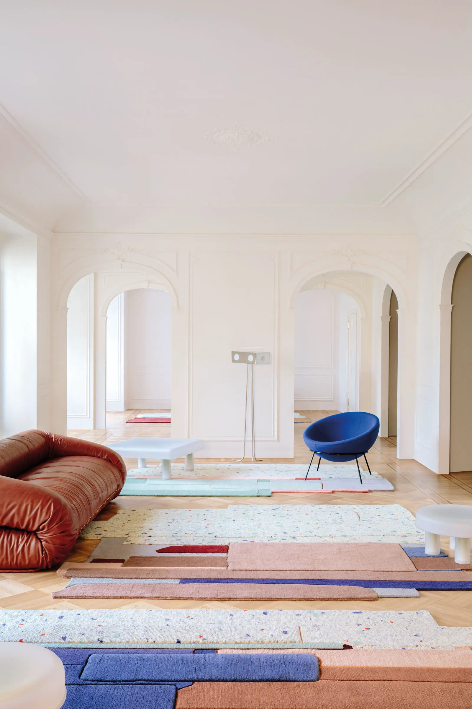 Colourful geometric cc-tapis rugs in an arched interior