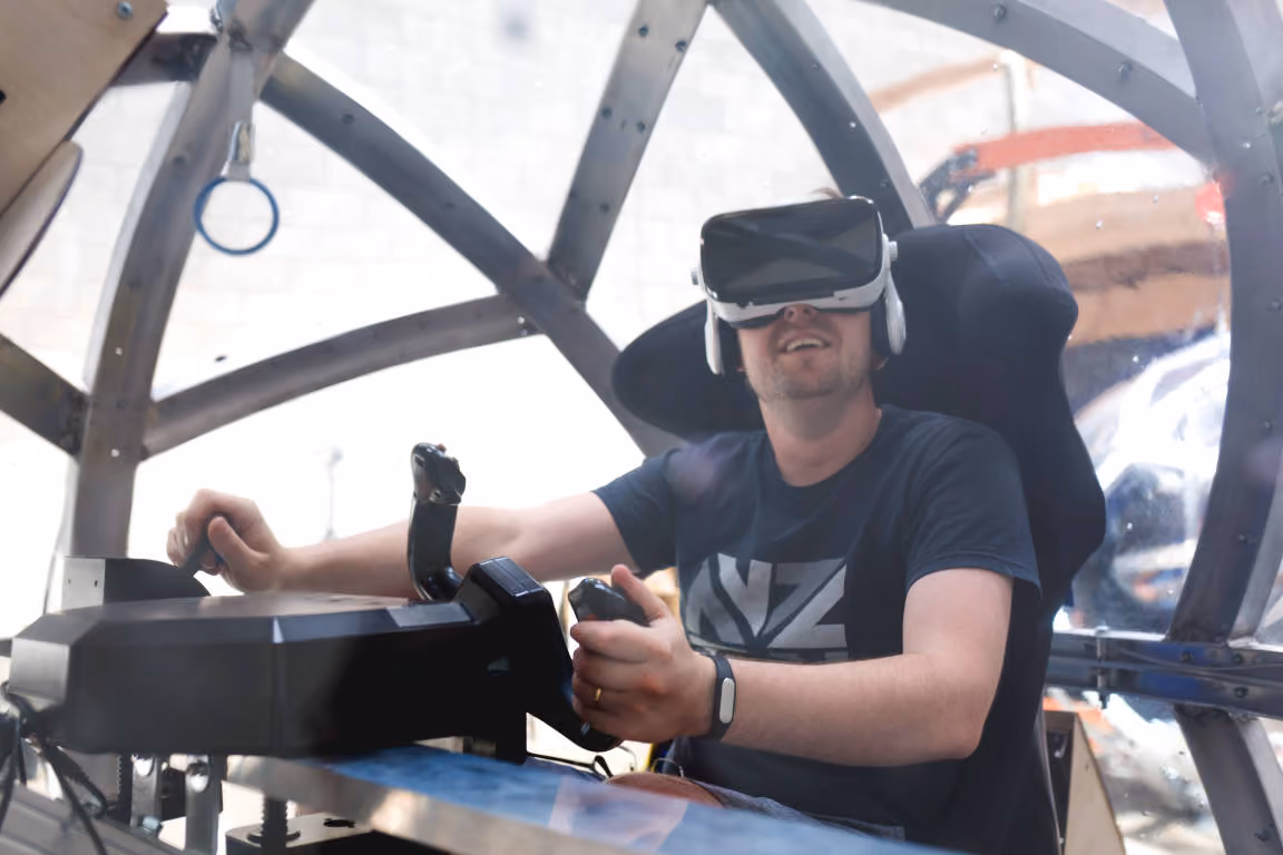Terry Miller, Founder and CEO of Eight360 pictured inside a NOVA unit with VR headset and flight yoke in a flight simulation.