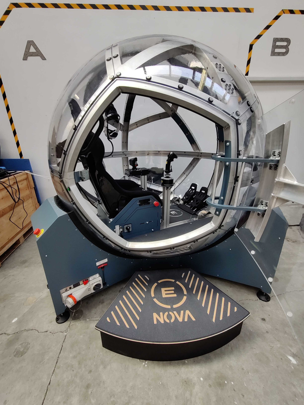 NOVA simulator with door open, showing seat, VR headset and flight controls inside.