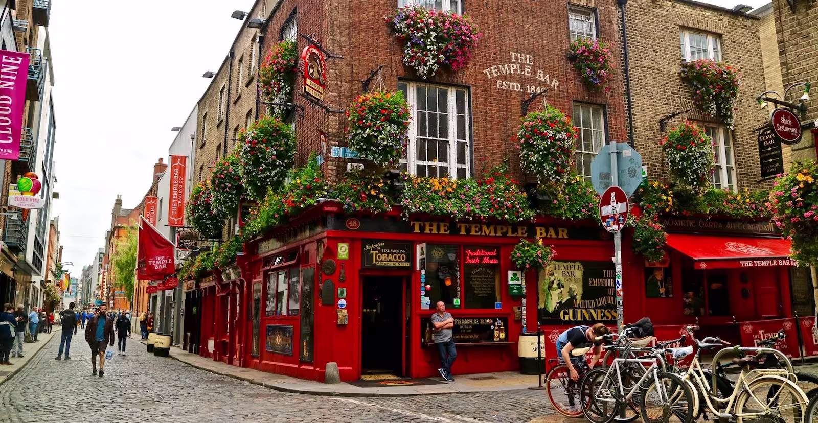 Red Building in temple bar with people walking on cobbled streets