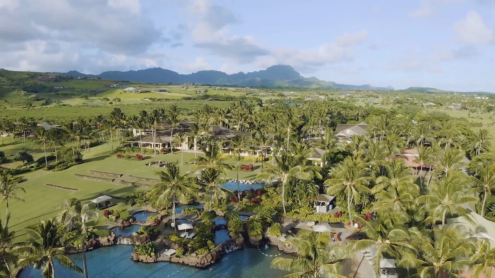 Aerial view of resorts in Hawaii with green trees and hills