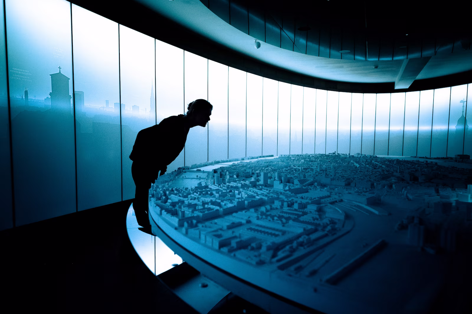 Person leaning over minature city exhibition