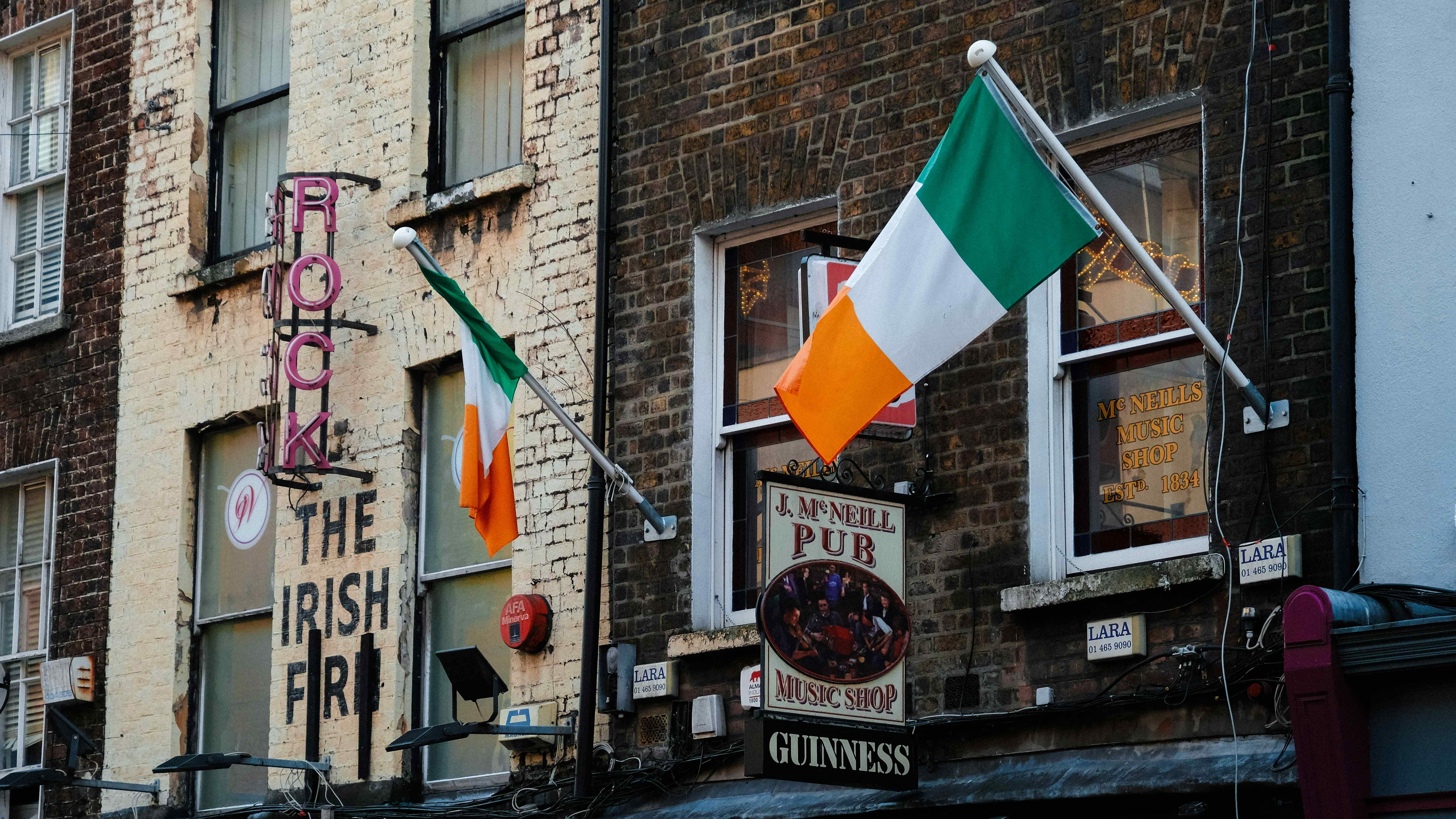 Ireland flag and pub signs on side of building 