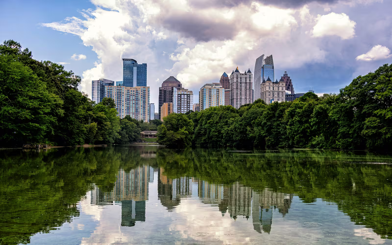 Piedmont Park with skying of city, pond and trees on cloudy bright day