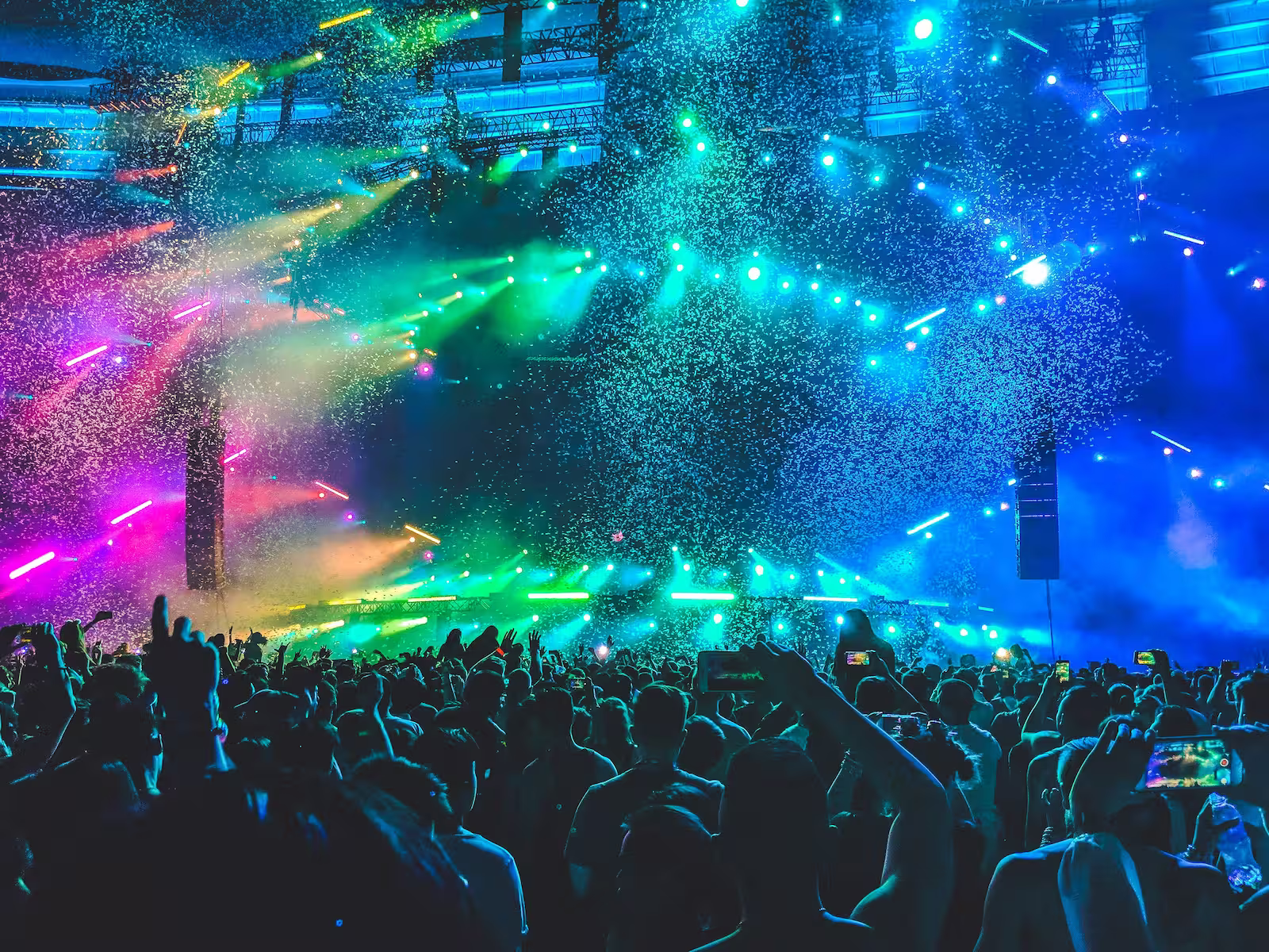 Large group of people at DJ set with confetti and club lights