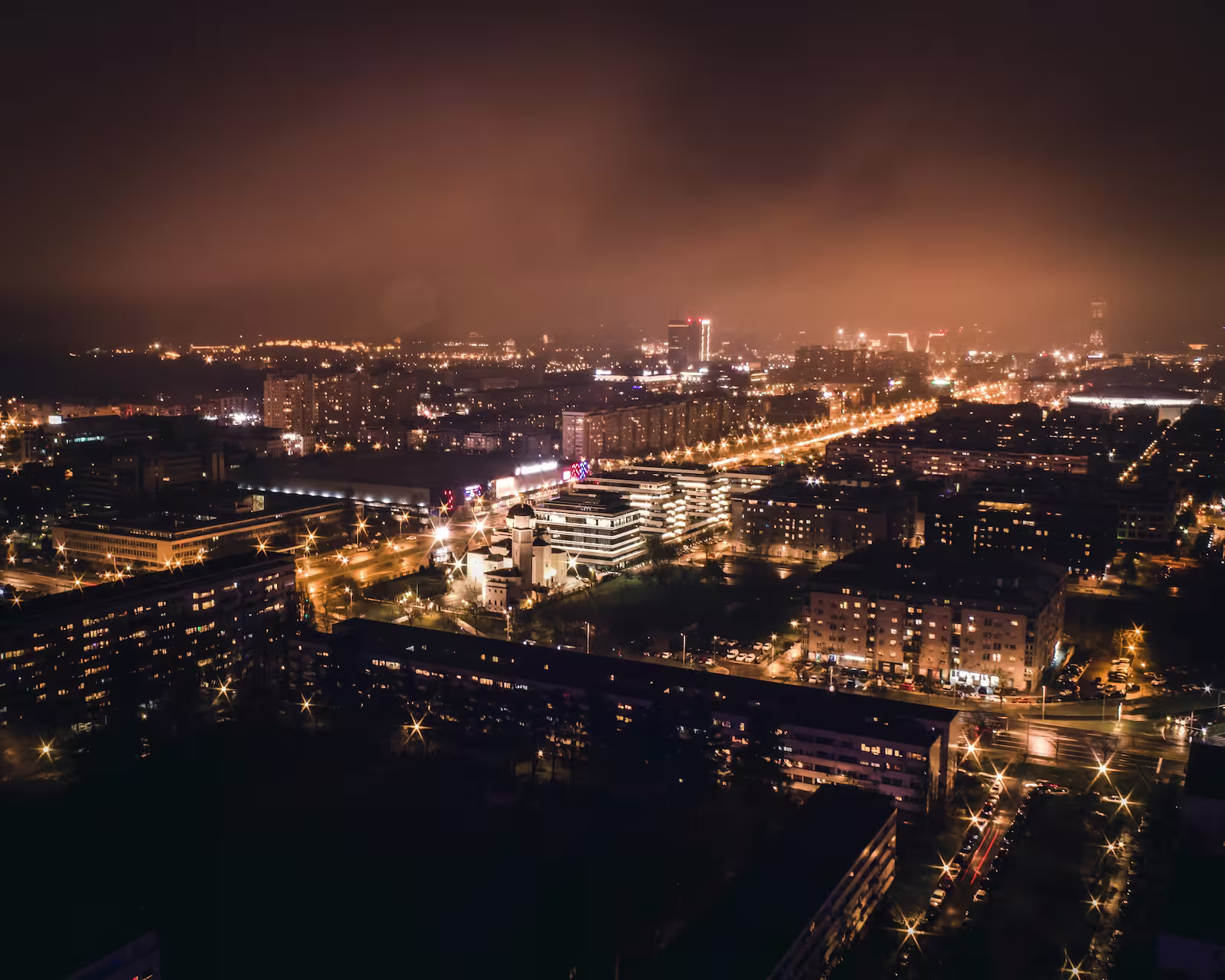 Aerial view of Belgrade at night with building lights and fog
