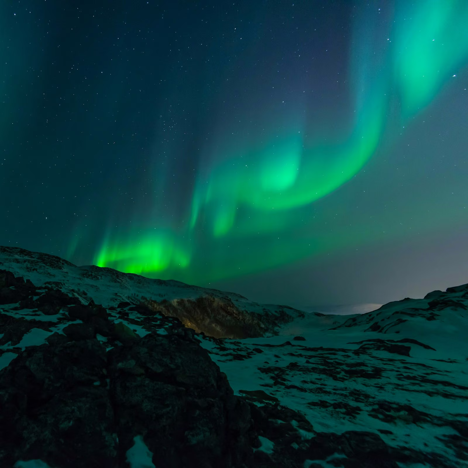 Northern lights above a snowy landscape in Tromsø, Norway