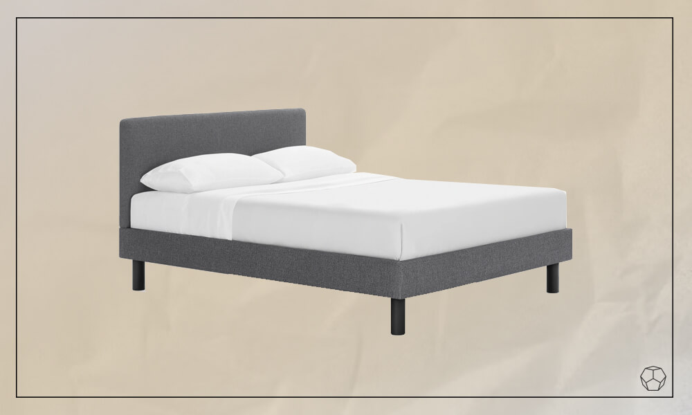 Grey upholstered bed with a mattress with white sheets and two pillows