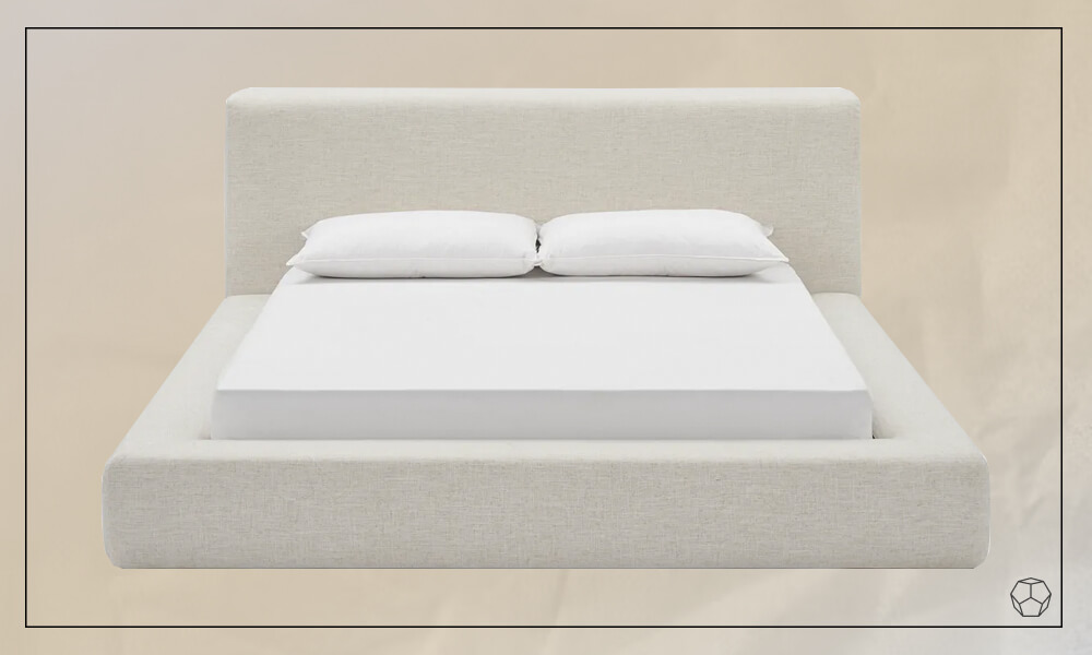 Low-profile white upholstered bed with an upholstered headboard, a white mattress and two pillows
