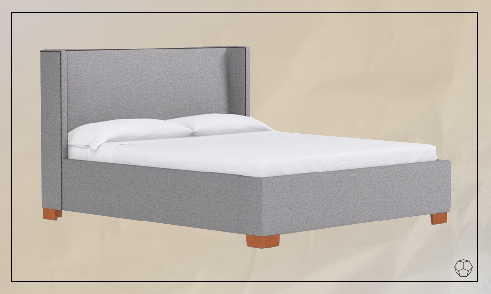 Grey Upholstered Bed with small wooden legs, a mattress with white sheets and two white pillows