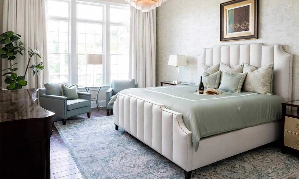 Upholstered Bed Frame in a bedroom near a window, two chairs, a rug and bedroom furniture