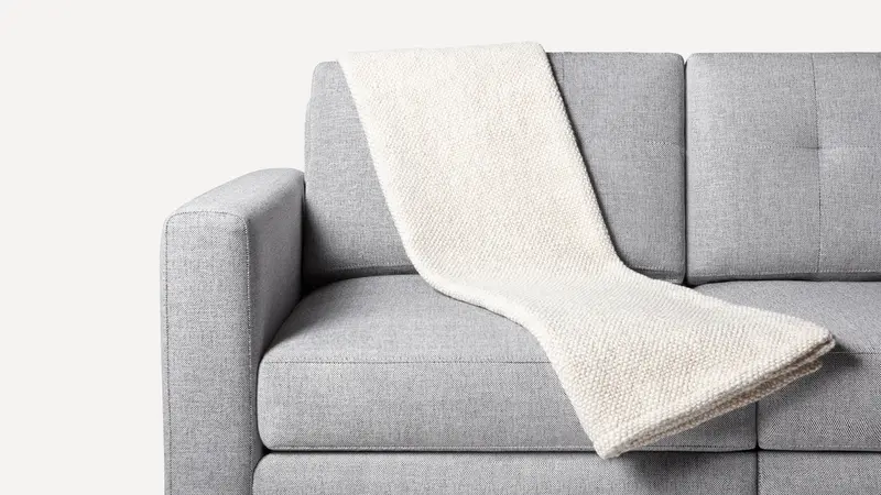 White throw blanket in a grey upholstered sofa