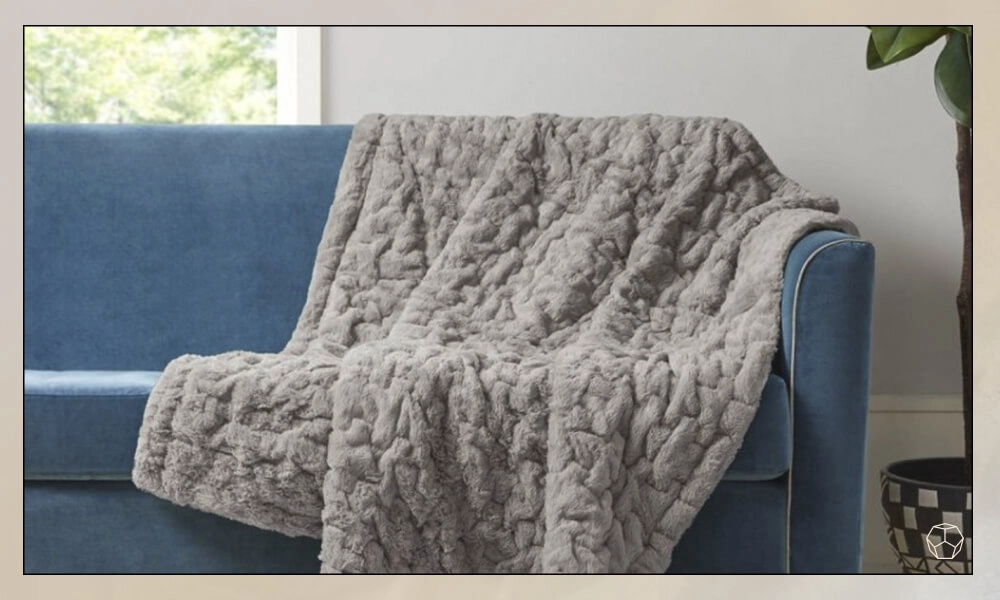 Ruched Faux Fur Throw Blanket in Grey Color in a blue sofa