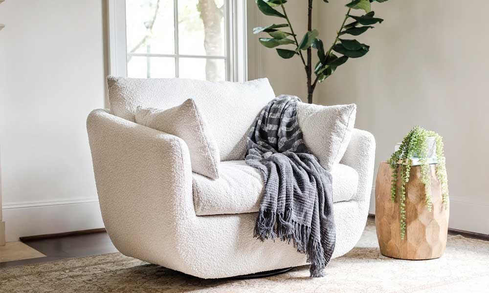 White Swivel Armchair with white throw cushions in a cozy living room