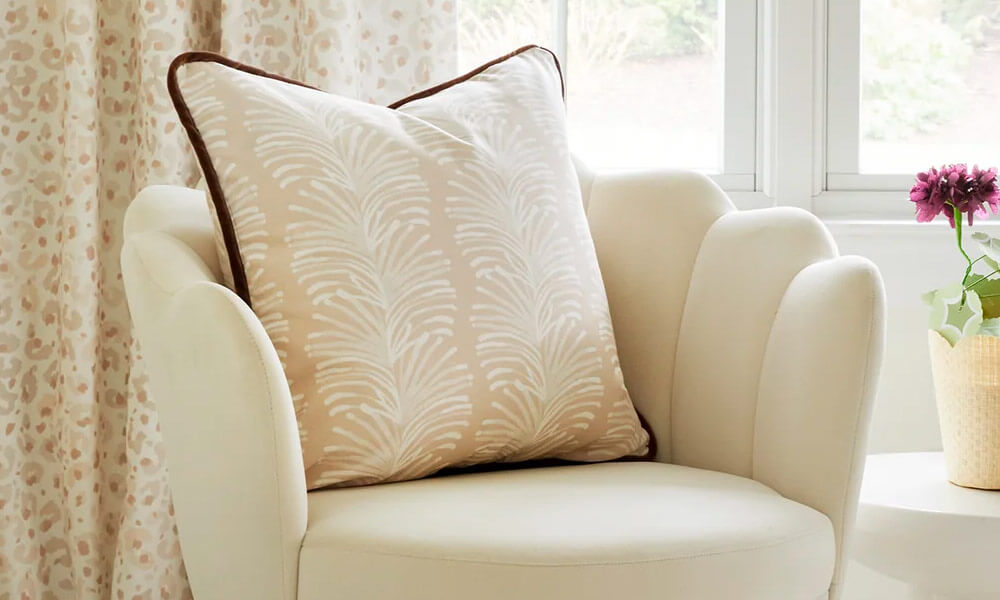 Sand Custom Pillow with white designs in a beige couch