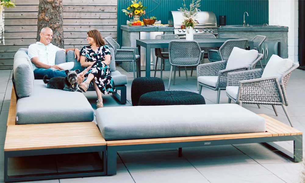 A couple enjoying a serene moment on a modern sectional in a patio, surrounded by a table and chairs