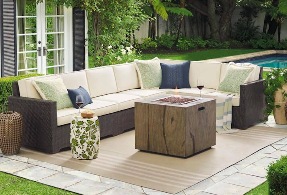 Dark brown Outdoor Sectional with white, light green and blue cushions in a backyard near a pool