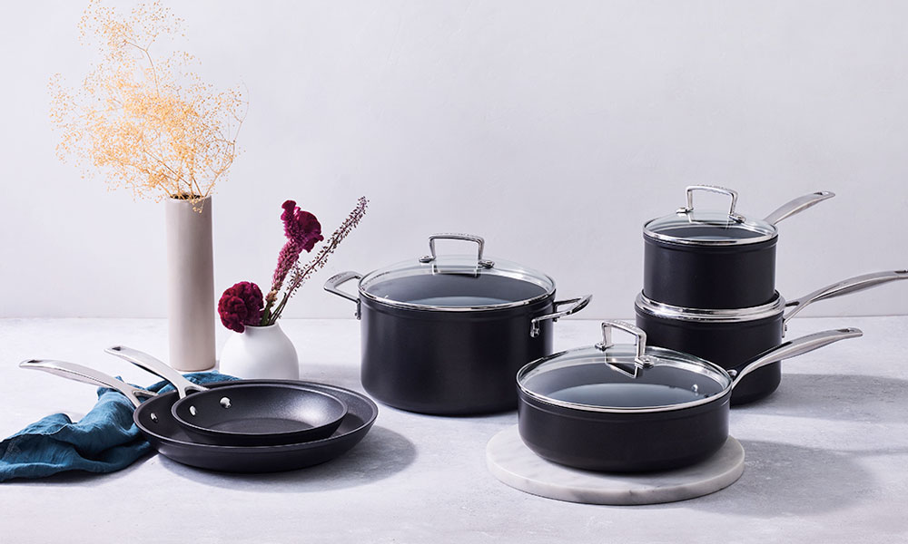 Black cookware set decorated with flowers and kitchen cloths
