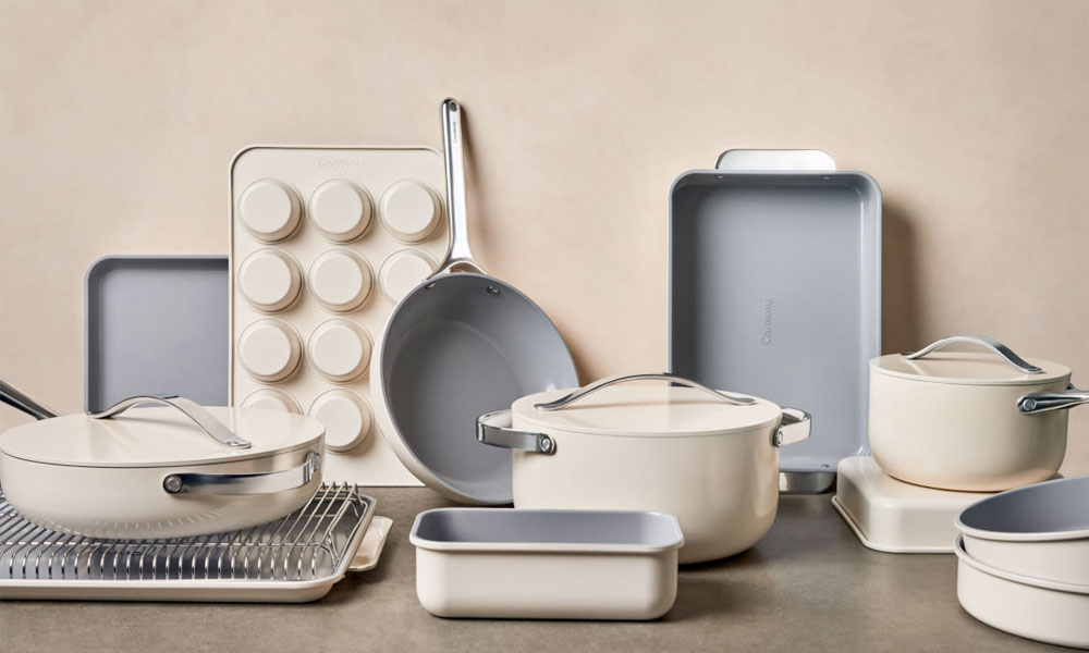 Display of white cookware with various pots and pans in a contemporary kitchen setting