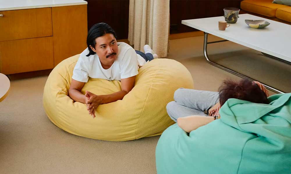 Two people talking while laying on two different bean bag chairs in a room