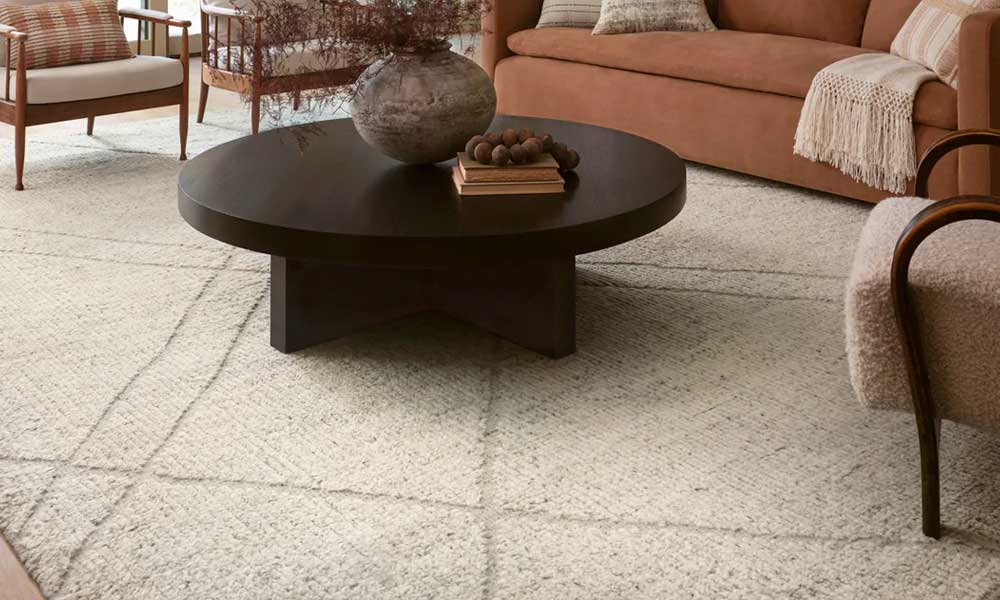 Light gray rug with diagonal lines in a living room with accent chairs, a sofa and a coffe table