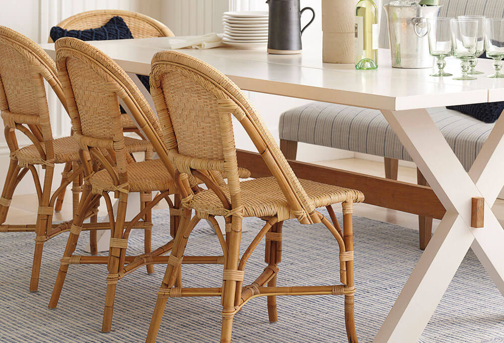 Rattan dining chairs arranged with a white dining table in a living room