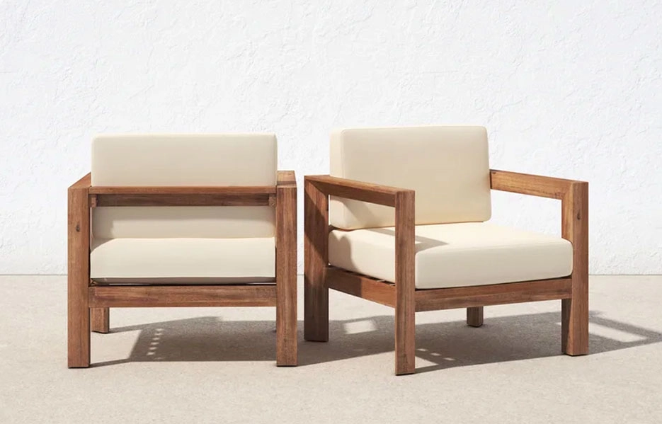 two wooden frame patio chairs with beige cushions