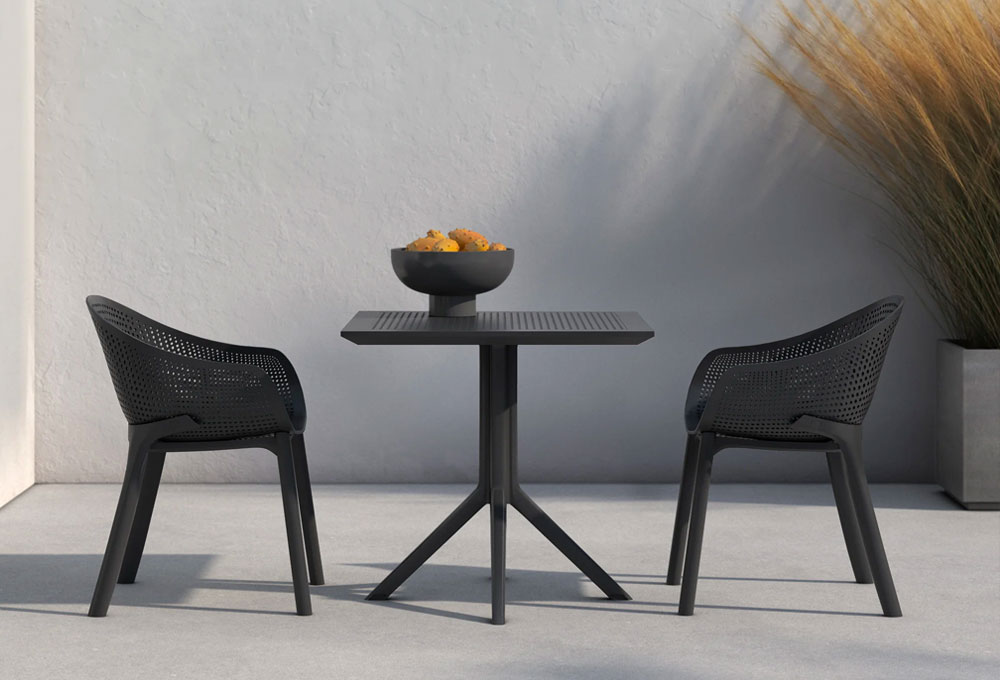 A patio with a black table and two chairs, creating a cozy outdoor seating area.