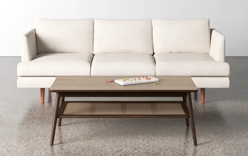 Rectangular wooden coffee table with a shelf placed in front of a white sofa
