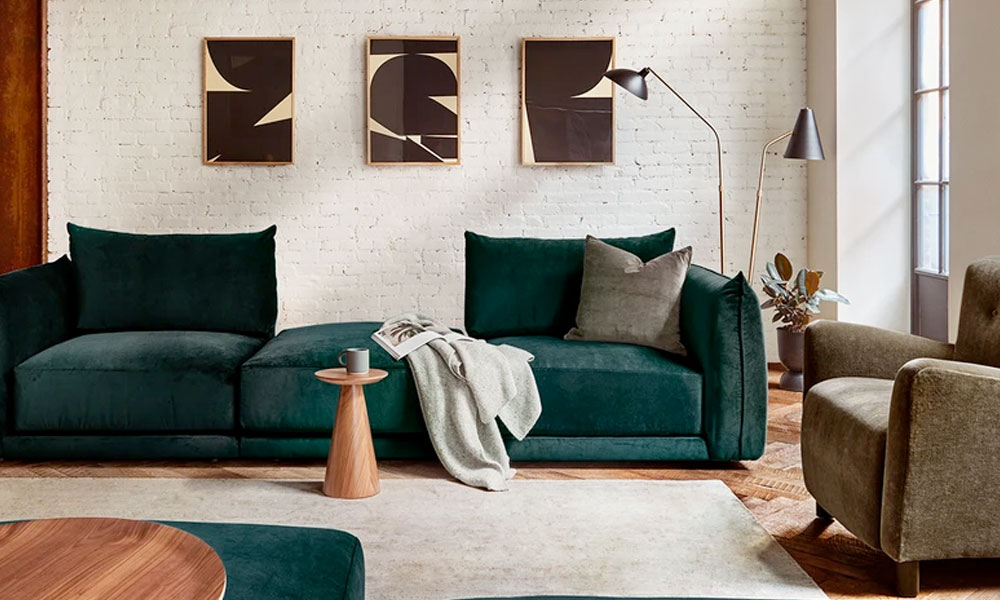 Green velvet modular sofa in a modern living room with a rug and a coffee table