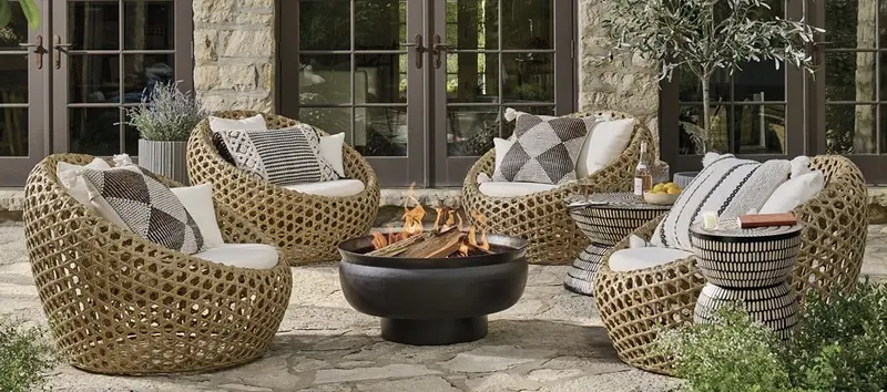 Outdoor patio furniture set surrounding a fire pit, creating a warm and inviting atmosphere