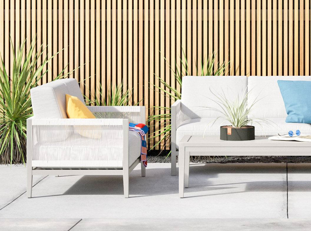 A white outdoor patio furniture set with blue cushions, creating a serene and inviting ambiance.