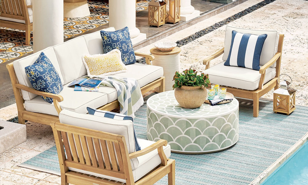 Outdoor furniture set with blue and white striped pillows, perfect for relaxing in the sun.