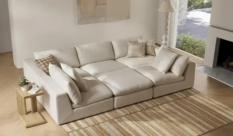 6 piece modular pit sectional sofa in light grey upholstery in a cozy living room