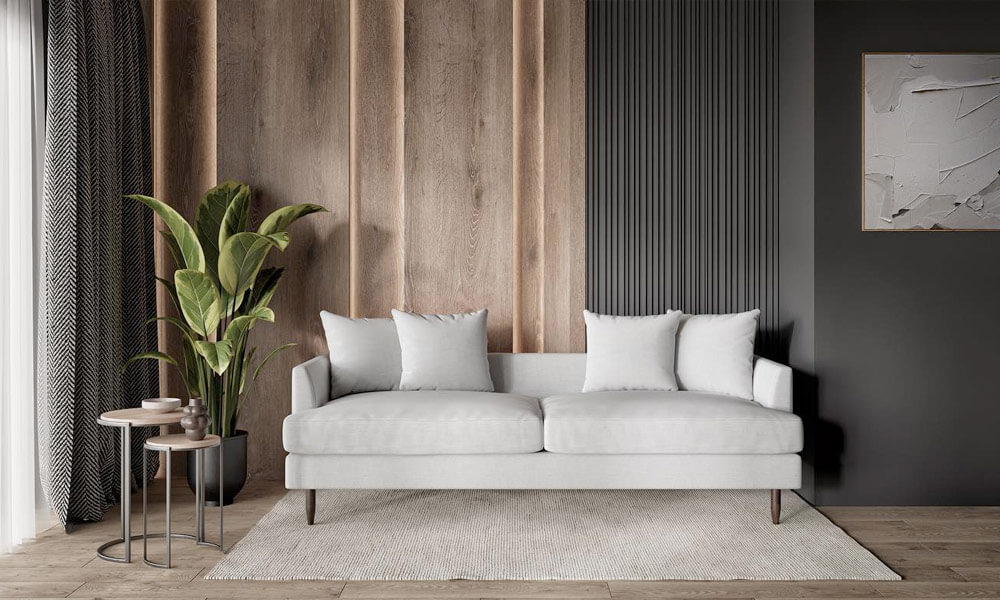 white upholstered sofa with dark legs in a living space with a white rug, plants and sidetables