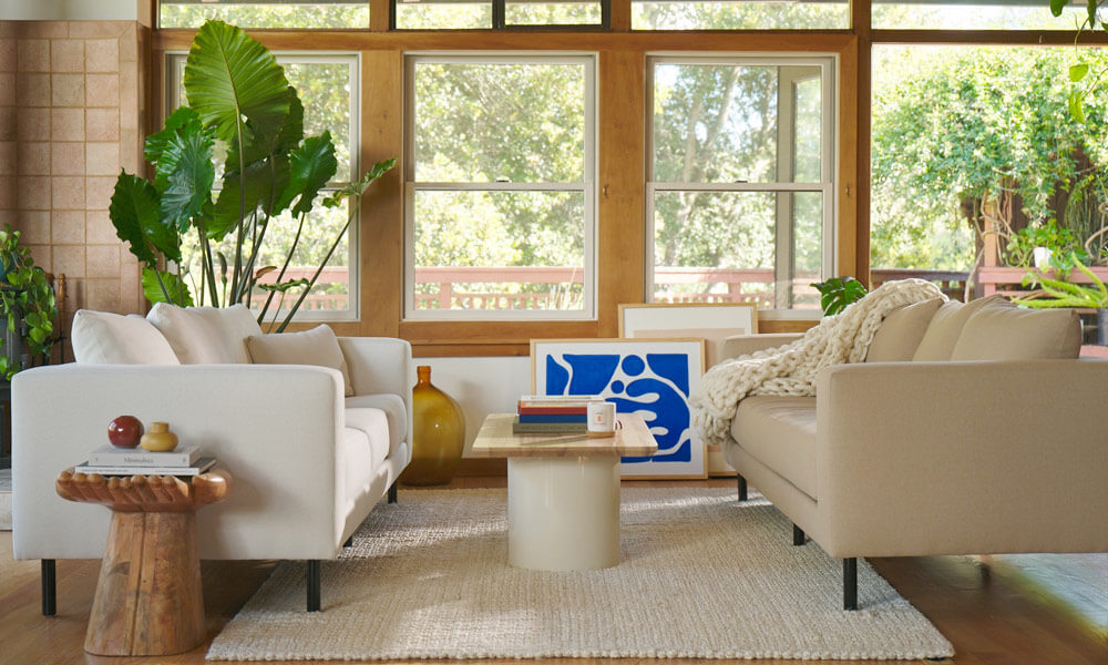 Living room with two sofas, one is white and the other one is light brown both with black legs