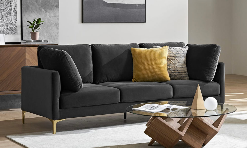 black velvet upholstered sofa with golden legs in a minimalist living space