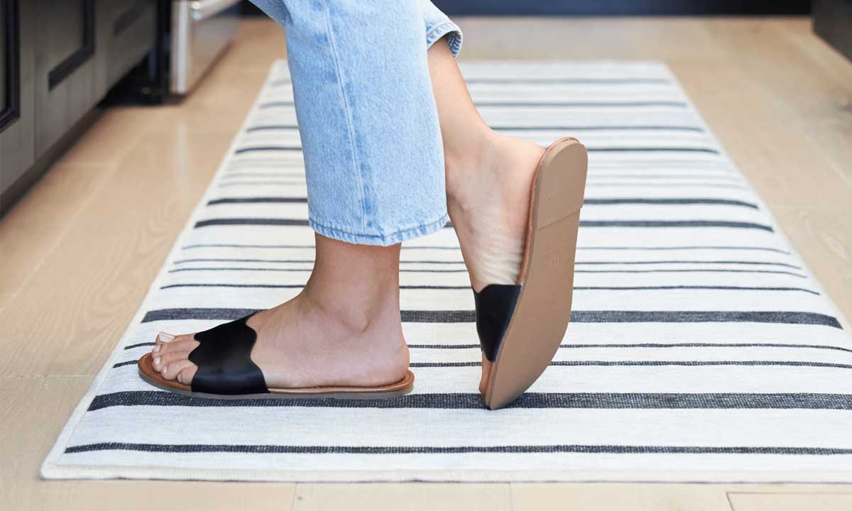 Rug on the kitchen floor, and a woman stood on it