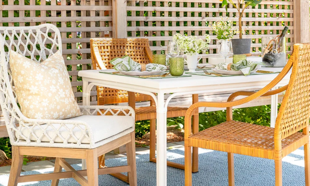 Rattan dining chairs with a white table in a patio