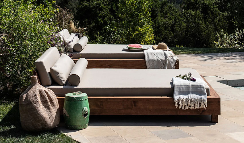 Wooden outdoor daybed with gray cushions and pillows