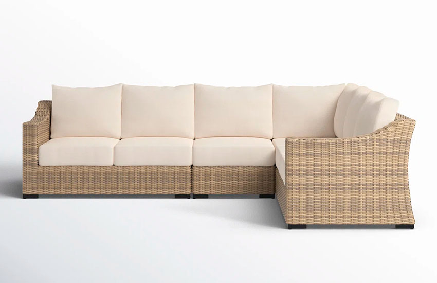 brown wicker sofa with beige upholstered seat and backrest cushions