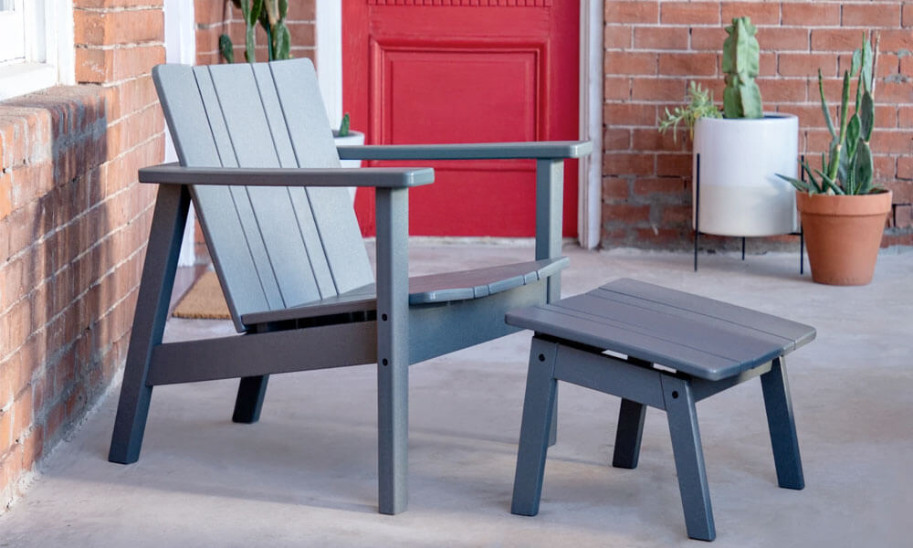 Grey Adirondack Chair and a ottoman near a red door