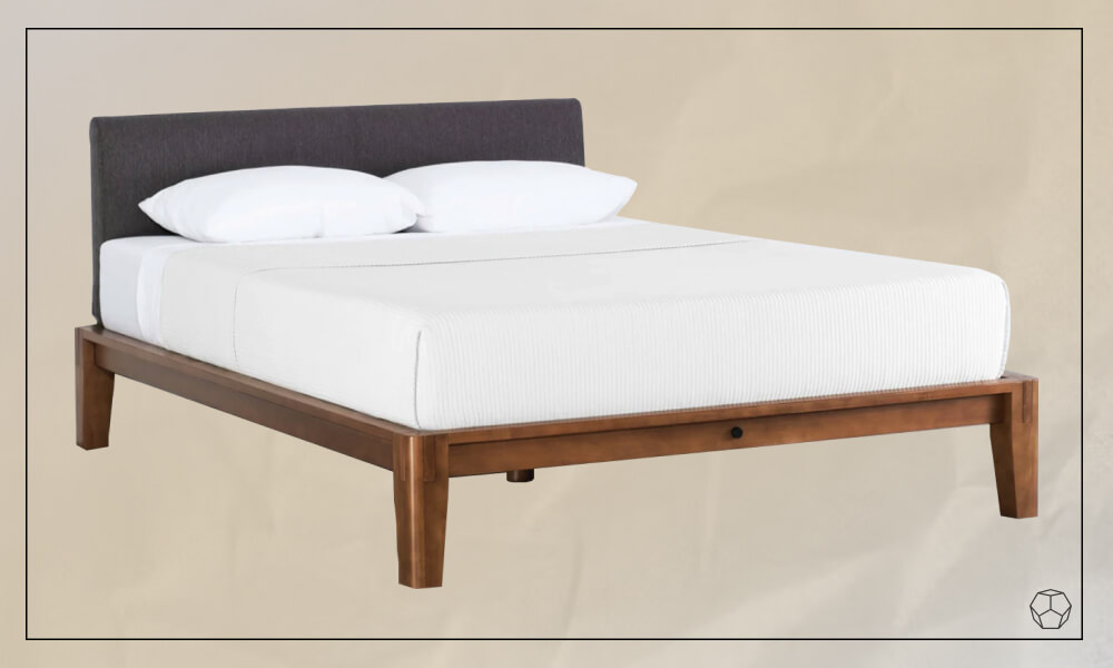 Wooden bed frame with a grey hedboard, a mattress and white sheets and pillows