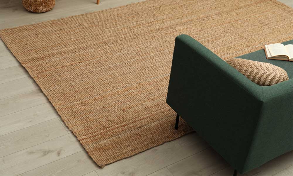 Light brown Rug near a green sofa with matching pillows