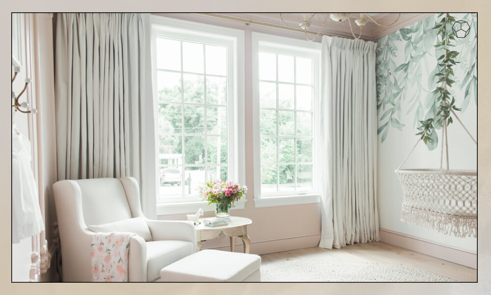 Long beige curtains in a cozy bedroom with an accent chair